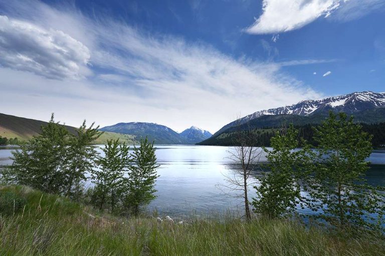 View of a lake, mountains in the background with blue sky